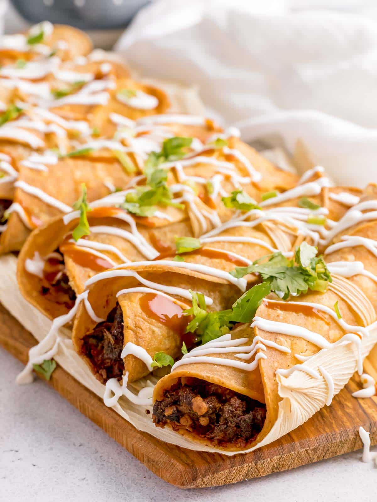 Air Fryer Ground Beef Taquitos served on a corn husk board.