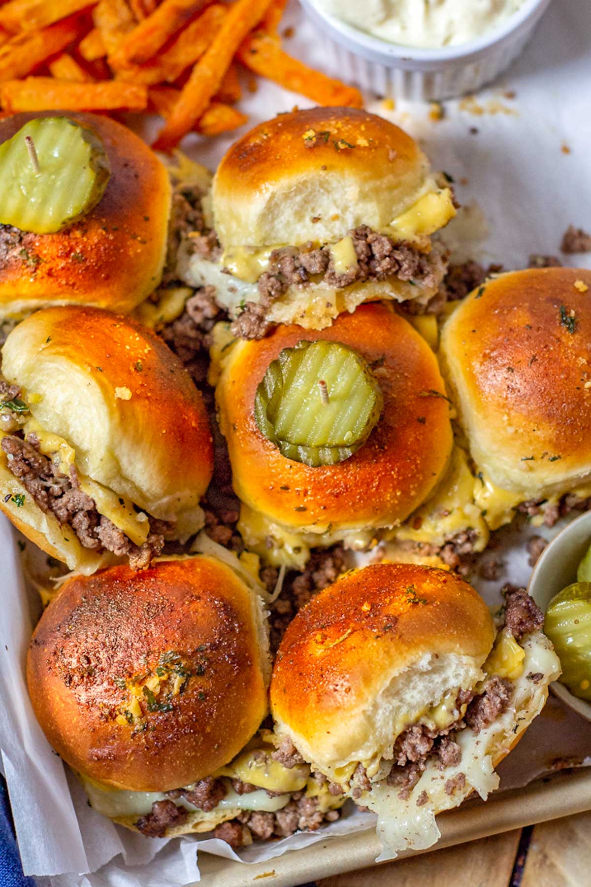 Baked Ground Beef Sliders are topped with a pickle.