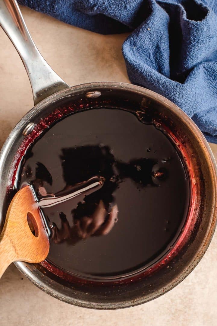 Red wine reduced to a glaze in a saucepan.