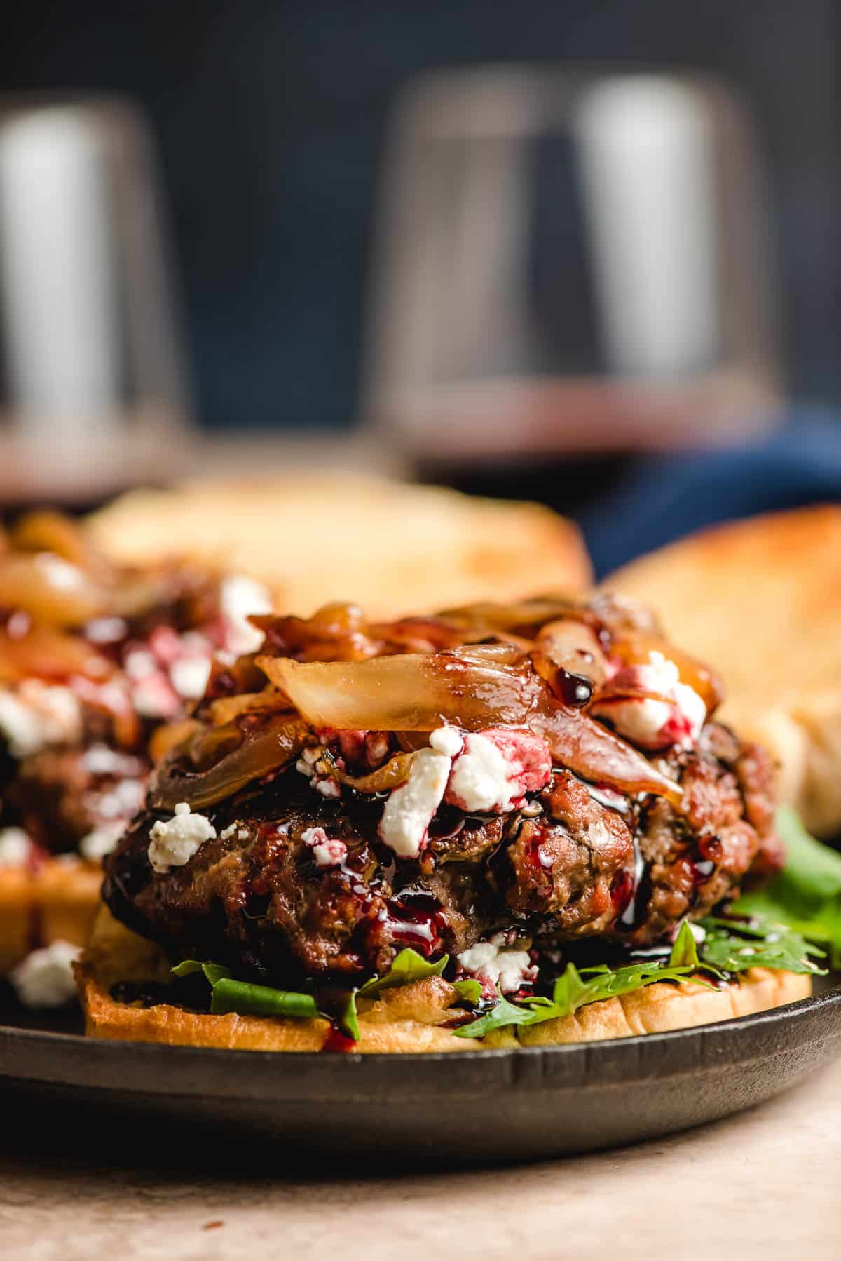 Open face burger topped with goat cheese, caramelized onions, and red wine sauce.