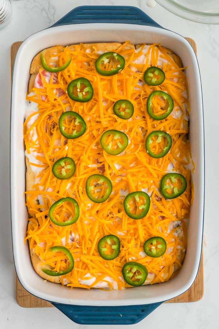 Shredded cheddar cheese and jalapeno slices atop a ground beef and biscuit casserole.