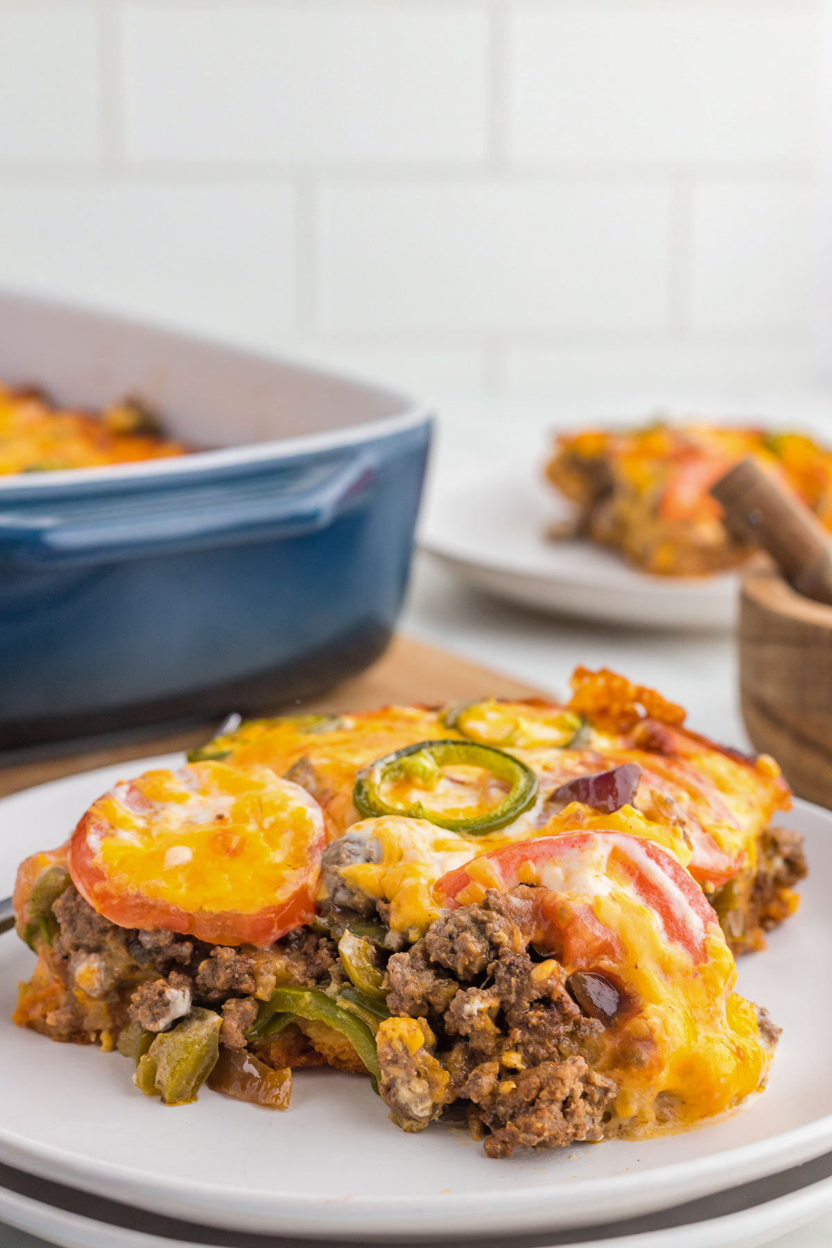 Slice of John Wayne Casserole with tomatoes and jalapeno on a plate.