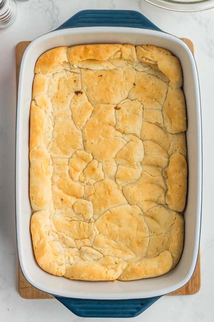 Baked biscuits smushed along the bottom and sides of a casserole dish.