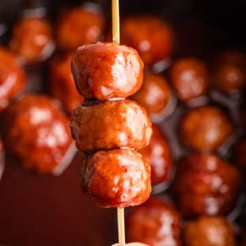 BBQ sauce and grape jelly meatballs skewered on a cocktail toothpick.