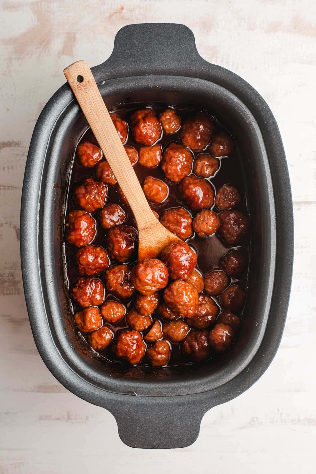 Crock pot full of cooked bbq grape jelly meatballs.