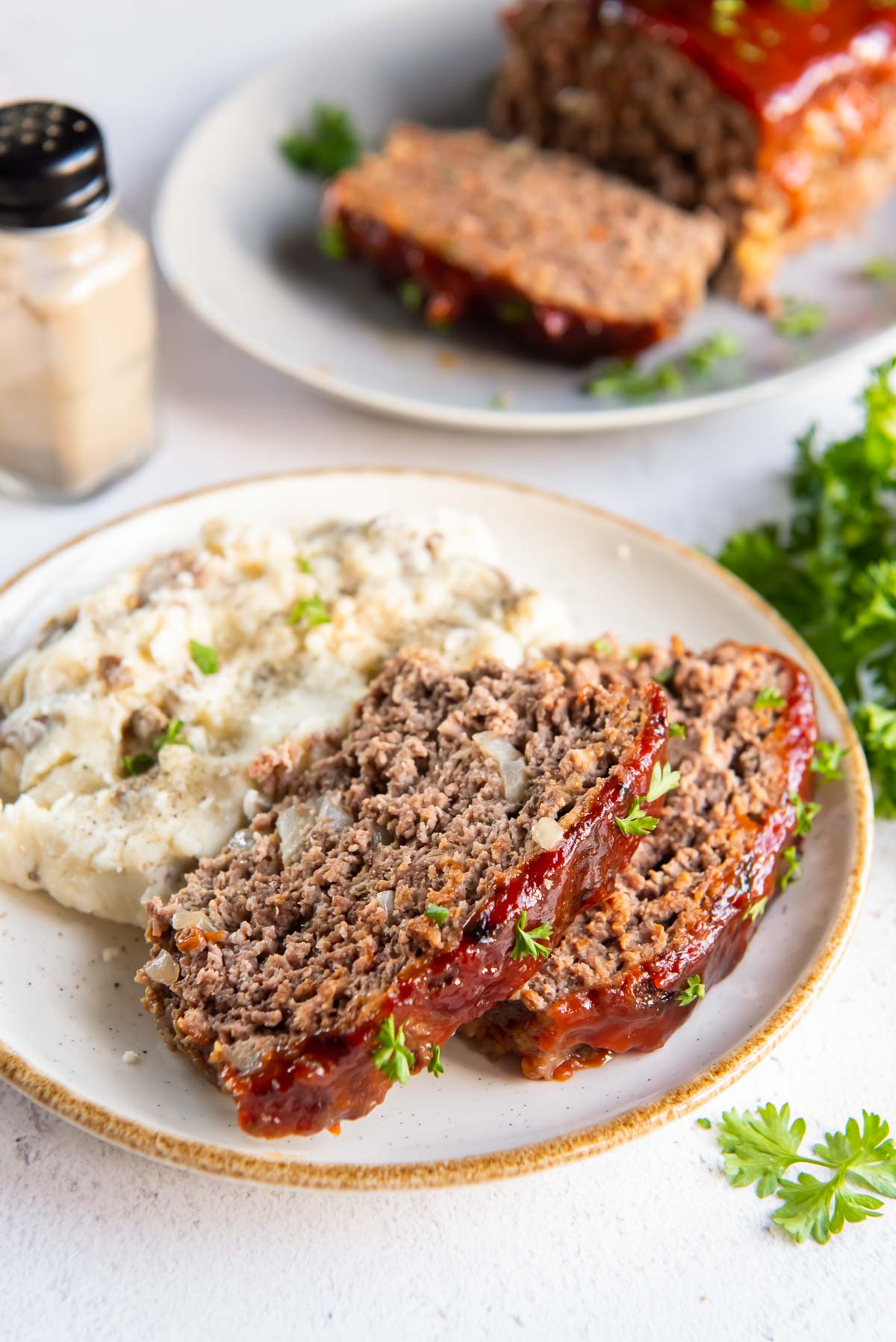 A plate of sliced air fryer meatloaf with mashed potatoes.