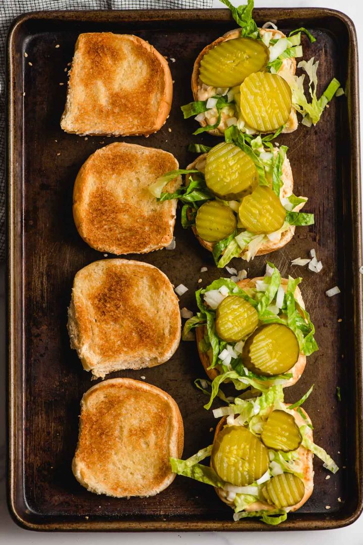 Toasted buns with pickles and lettuce.