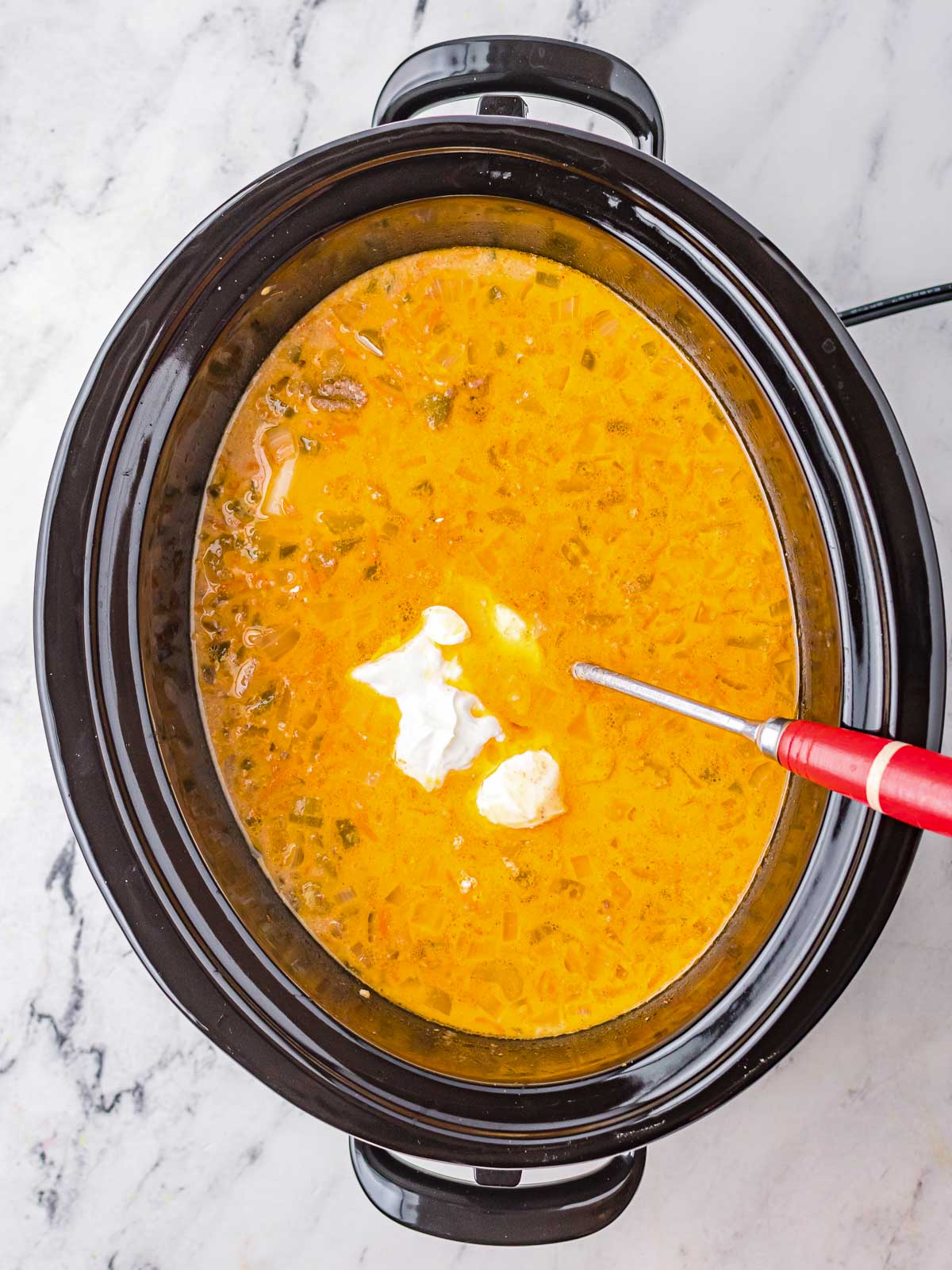 A dollop of sour cream is added to Crock Pot Cheeseburger Soup.
