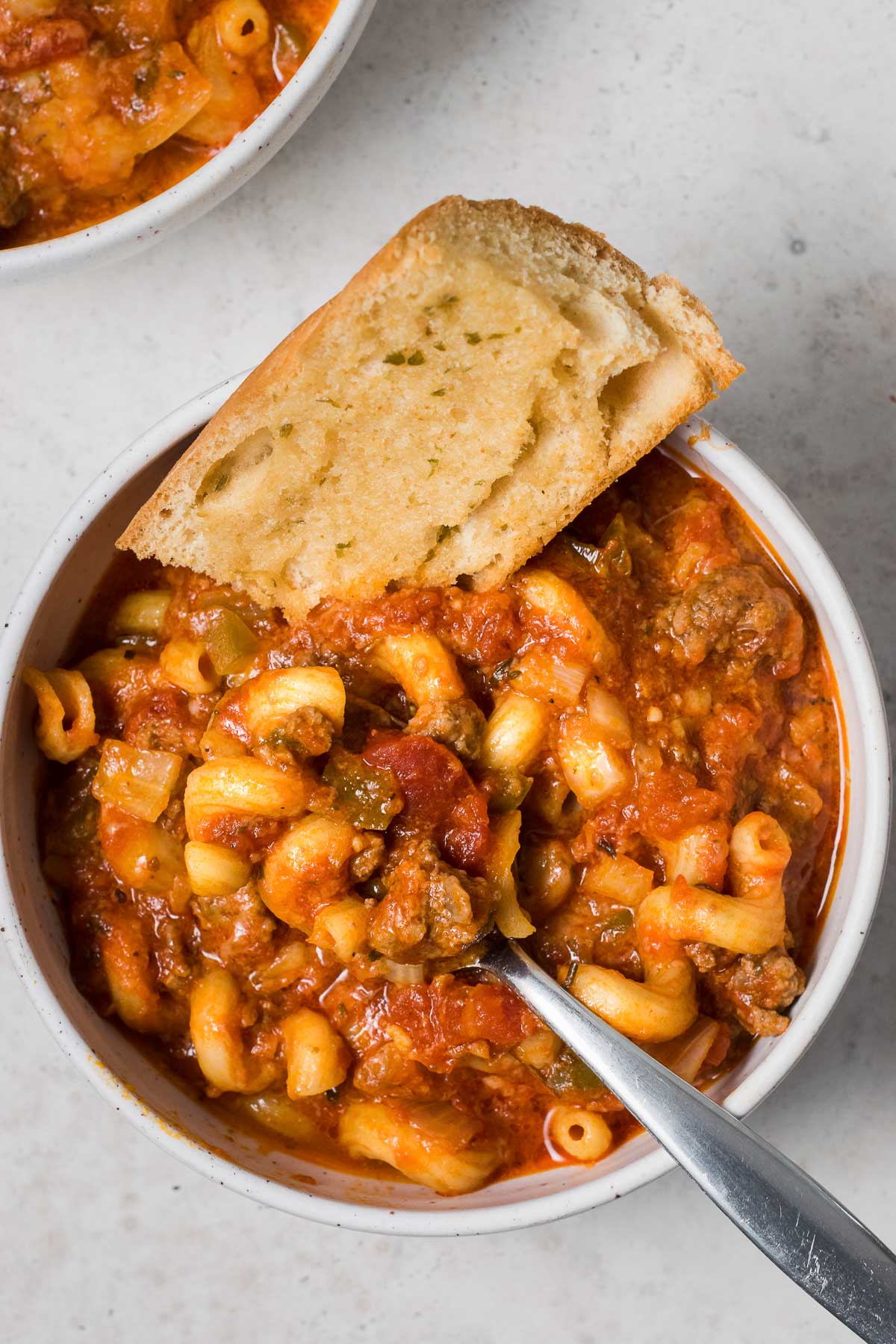 Bread and a spoon in a bowl of slow cooker goulash.