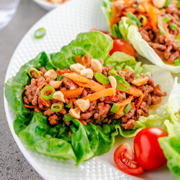 Ground Beef Lettuce Wrap topped with carrots and peanuts, shown on a white plate.