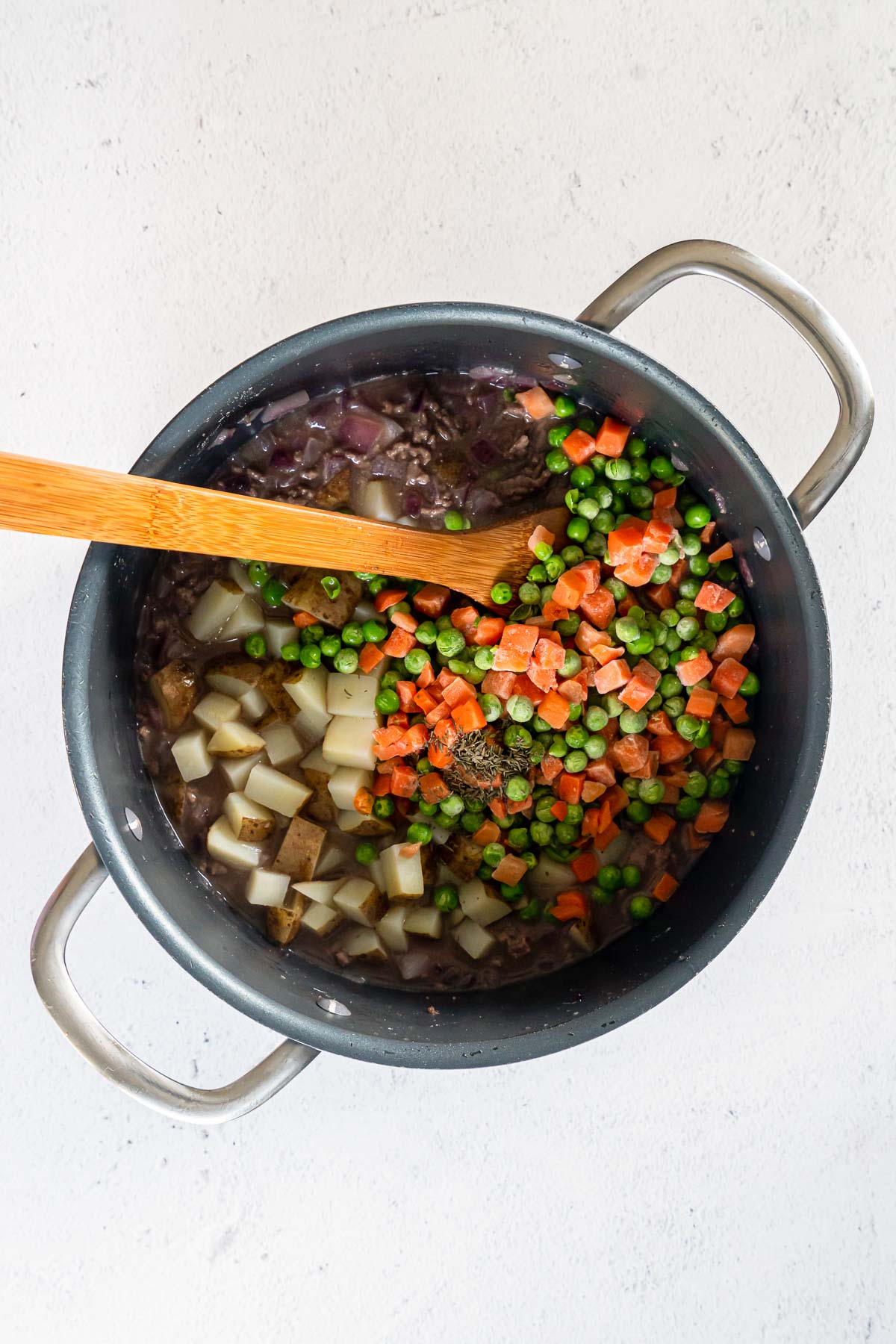 Frozen peas and carrots, diced potatoes, and broth and red wine in a large pot together.