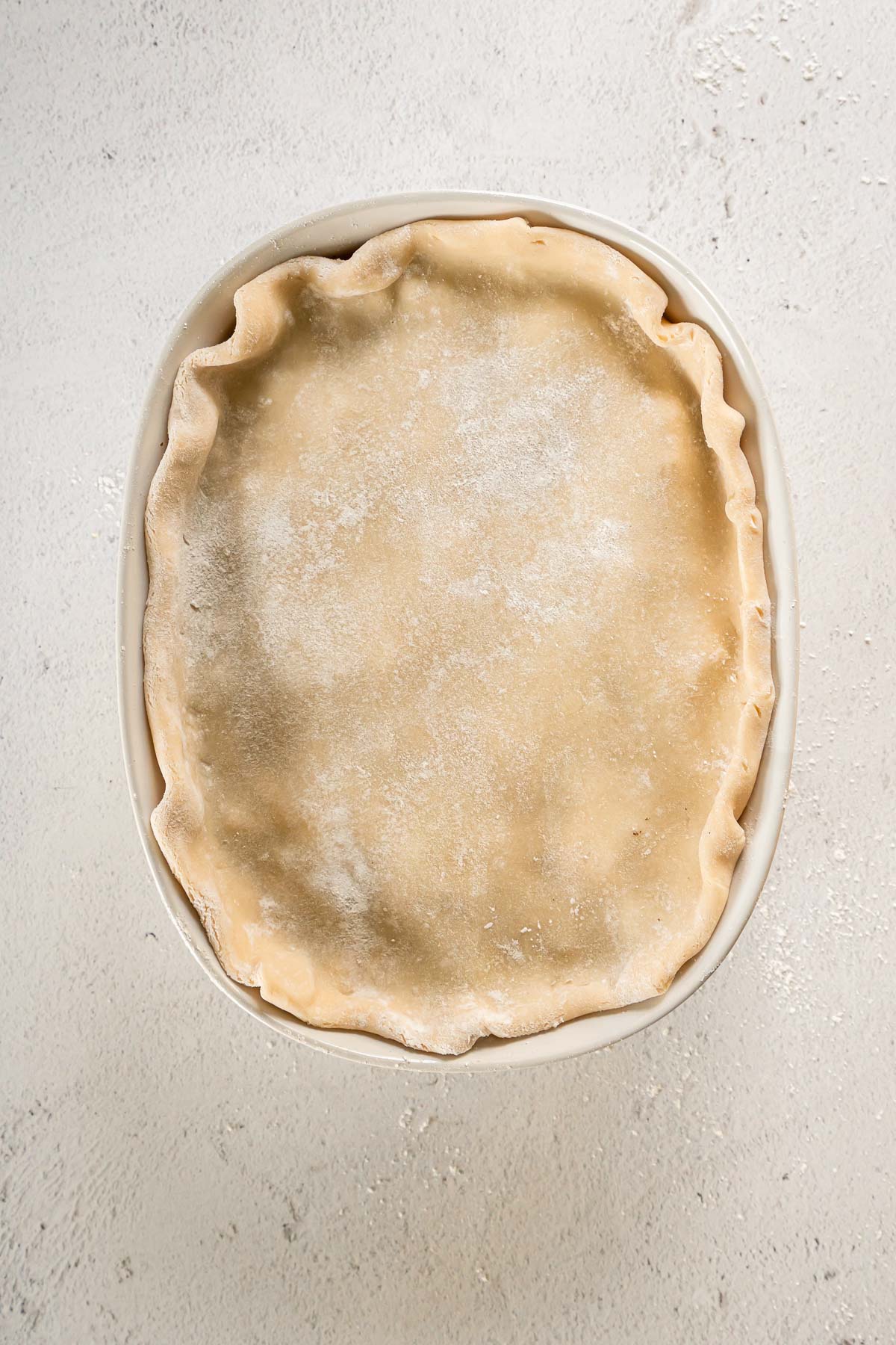 Pie crust shaped into an oval casserole dish.