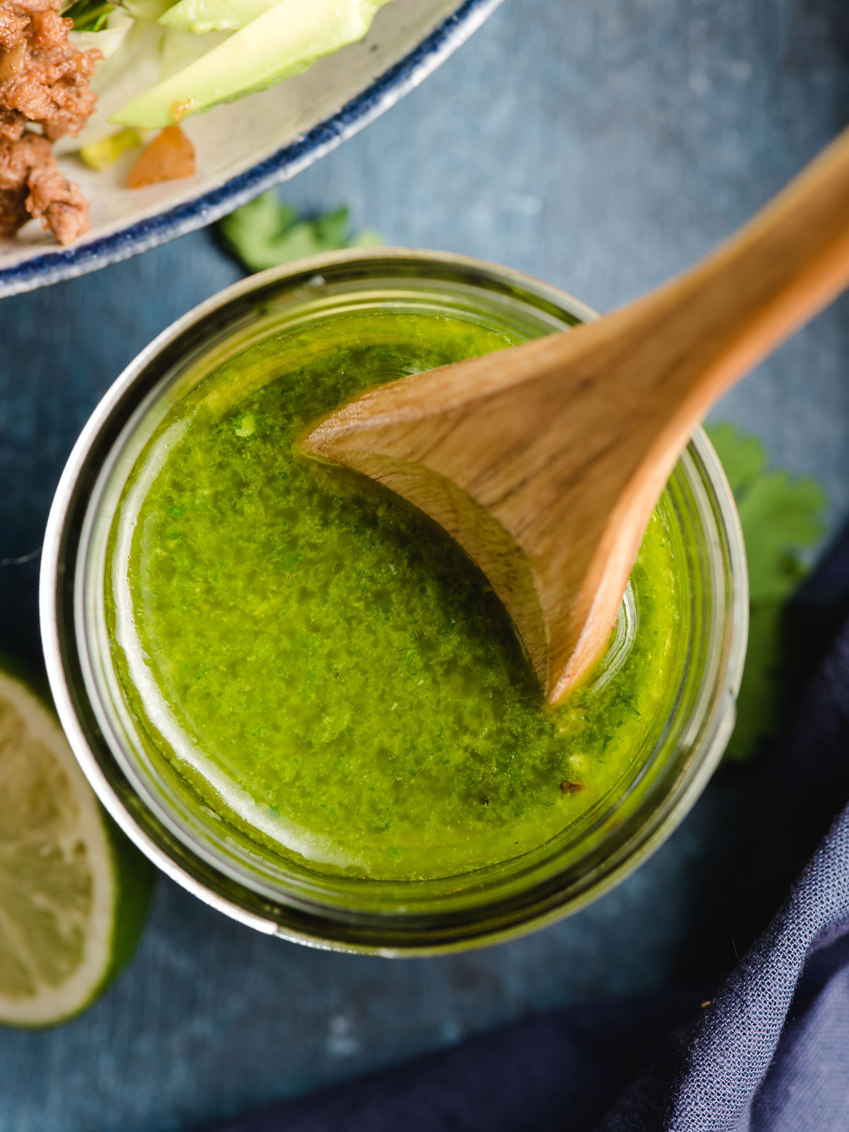 A spoon mixes a jar of homemade Cilantro Lime Vinaigrette that will serve as taco salad dressing.