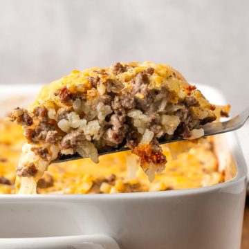Slice of Ground Beef Hashbrown Casserole lifted out of a baking dish.