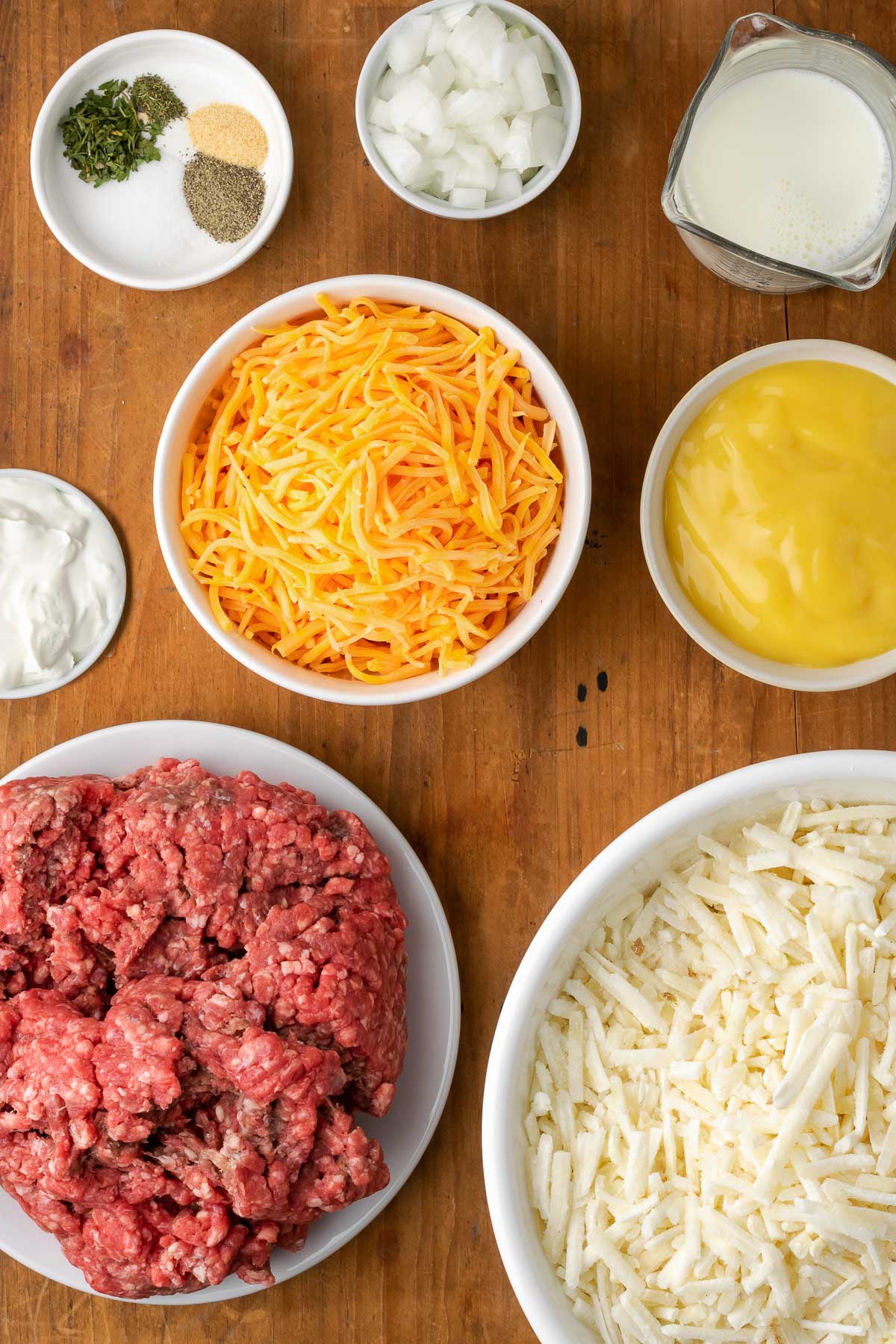 Ingredients for hashbrown casserole in white bowls.