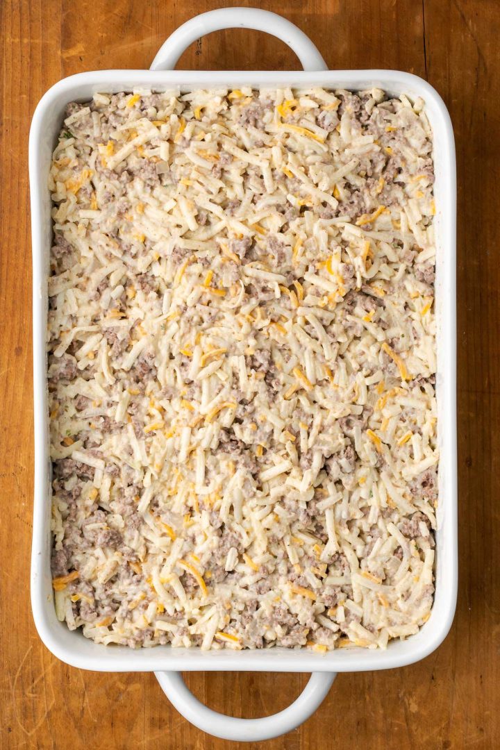 Mixture of hamburger, hashbrowns, and creamy sauce in a casserole dish.