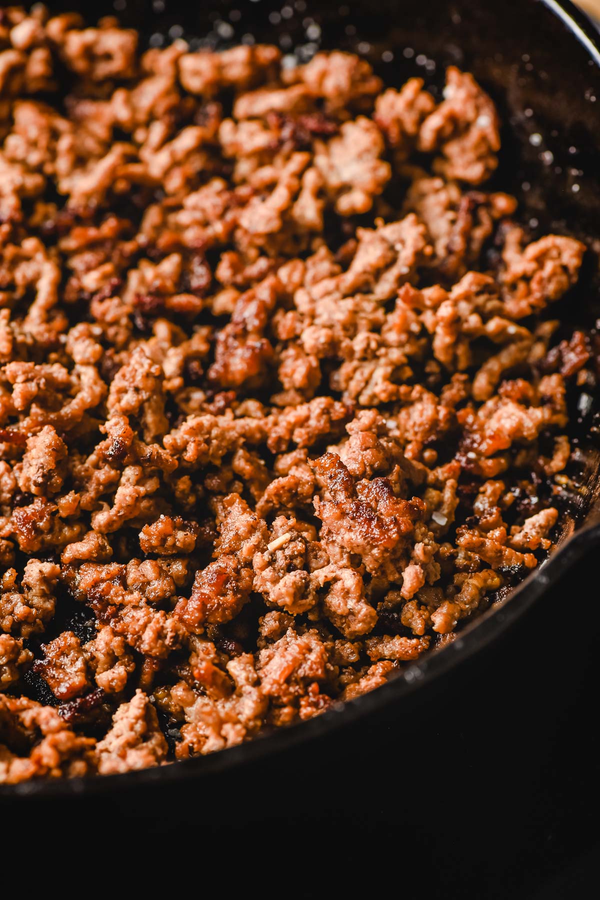Crispy browned ground beef in a cast iron skillet.