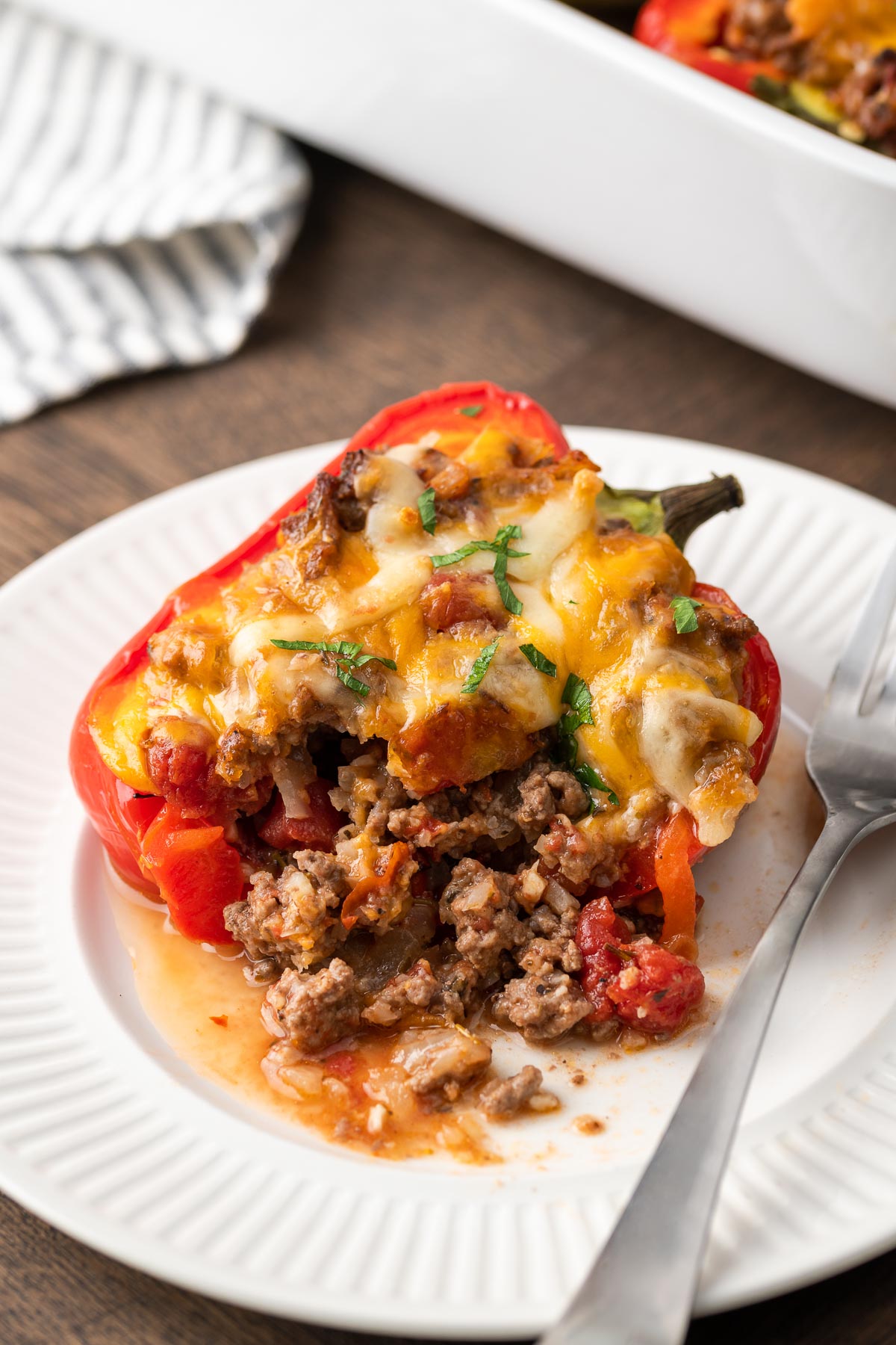 A cut open keto stuffed pepper shows the ground beef filling.
