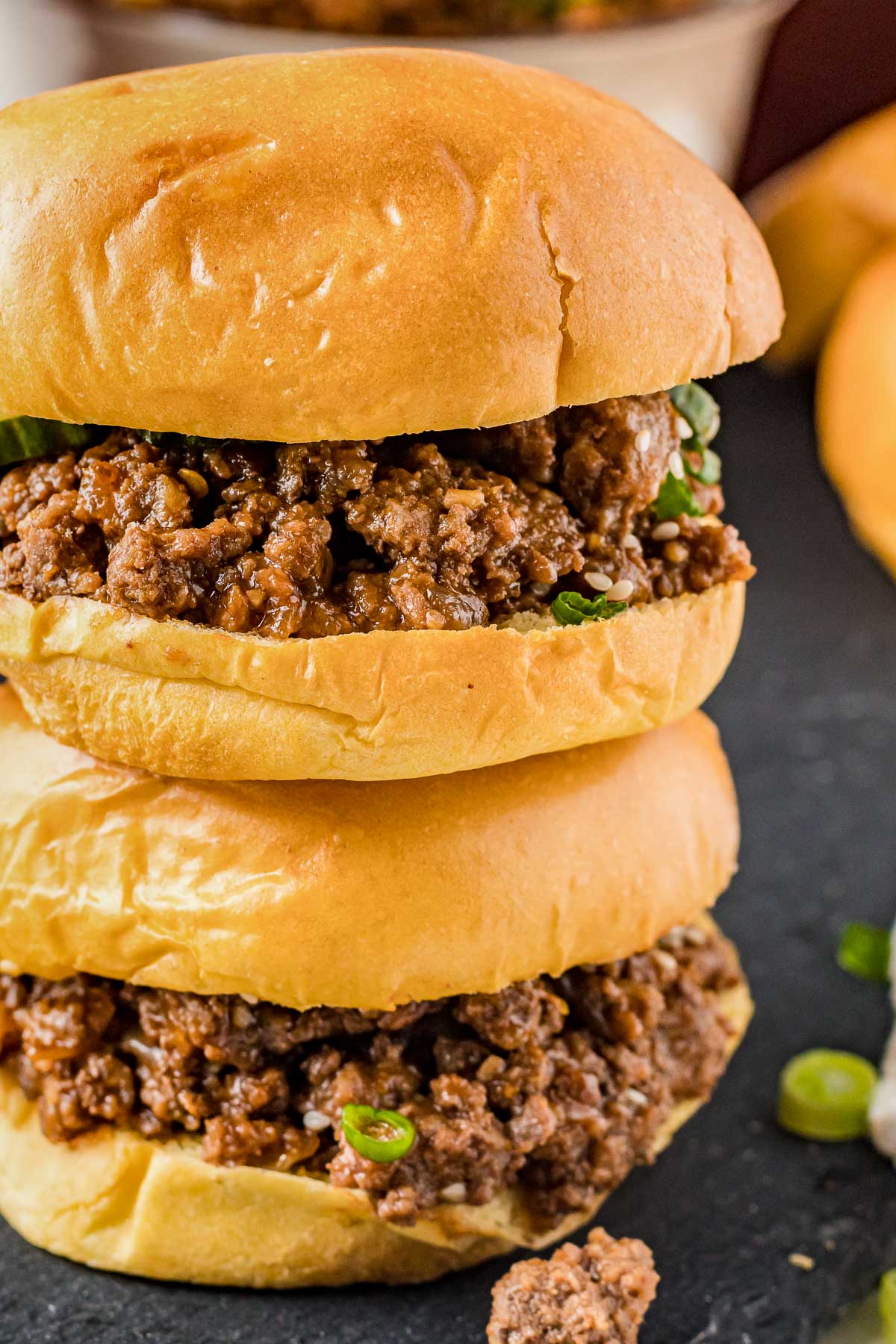 Stack of two Korean Sloppy Joes on a slate plate.