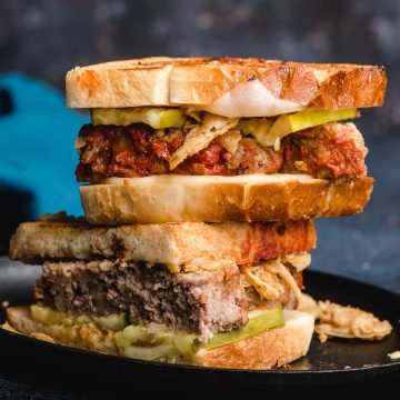 Hot Leftover meatloaf sandwich stacked on a plate.