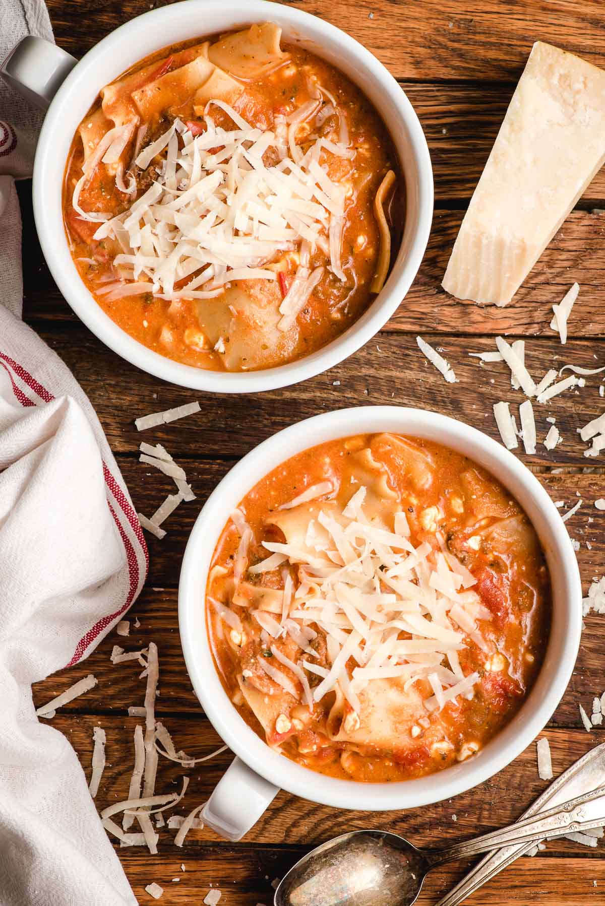 Two bowls of lasagna soup topped with shredded Parmesan cheese.