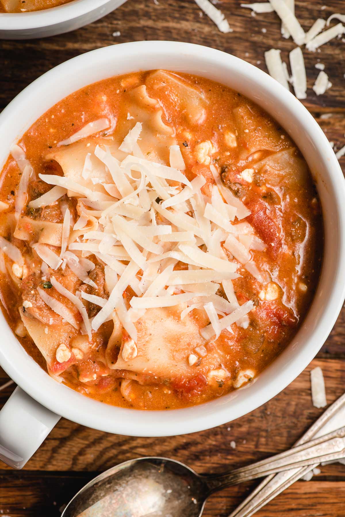 Bowl of lasagna soup with Parmesan cheese sprinkled on top.