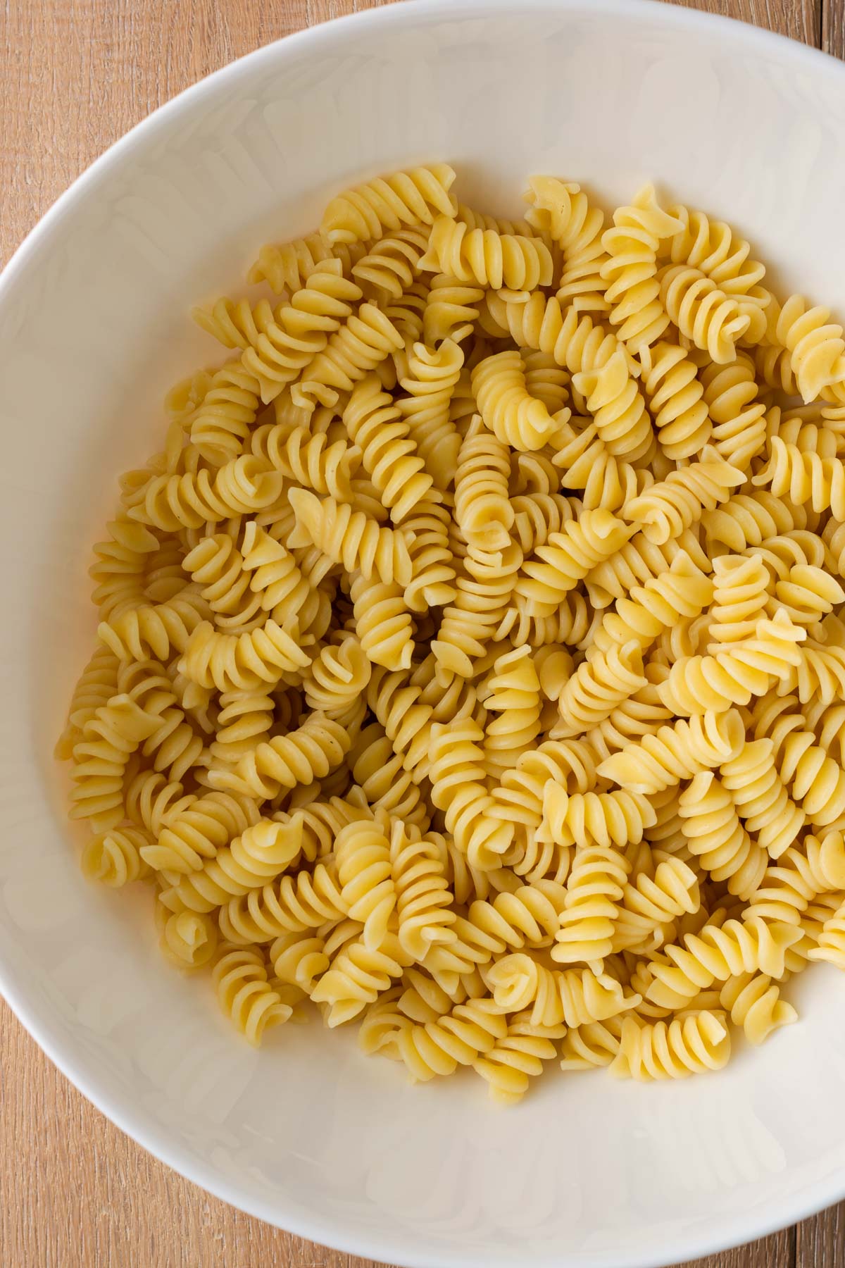 Bowl full of cooked rotini pasta.