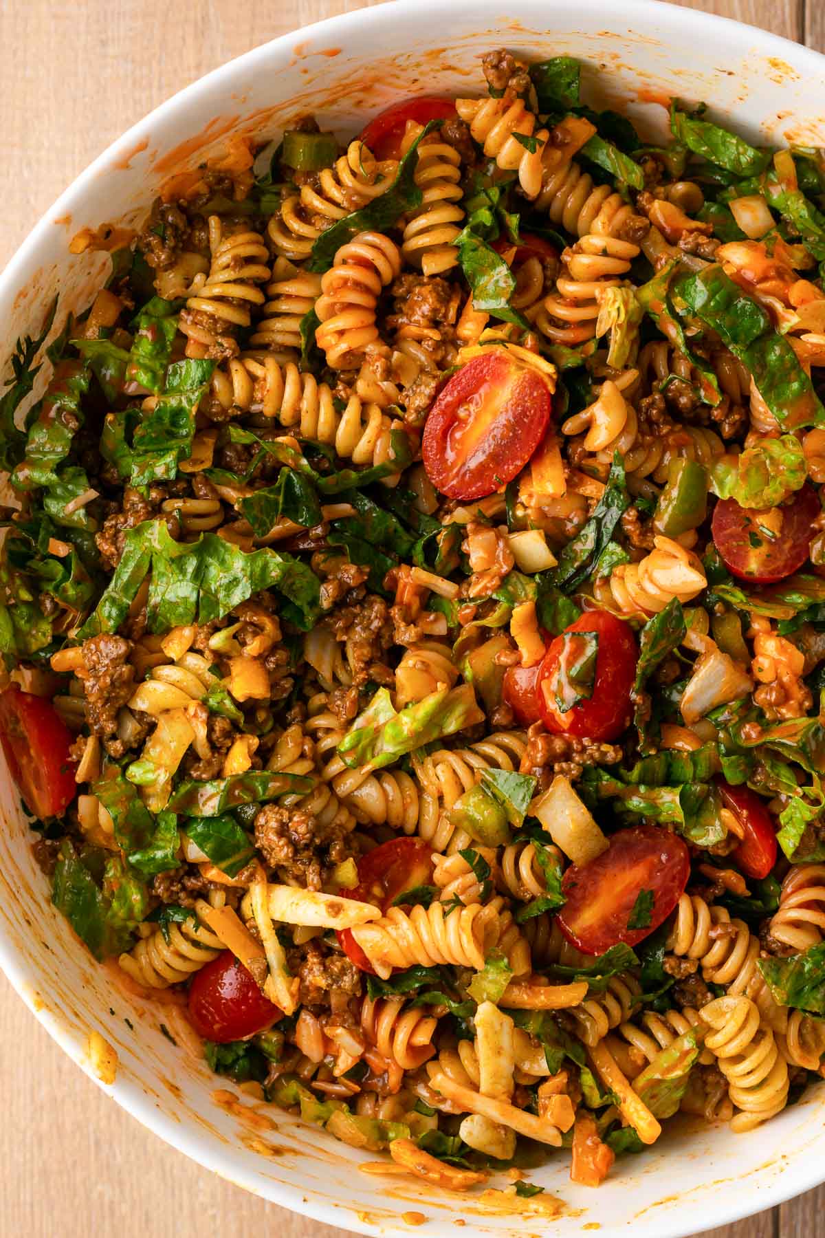 Taco pasta salad with ground beef in a big bowl.