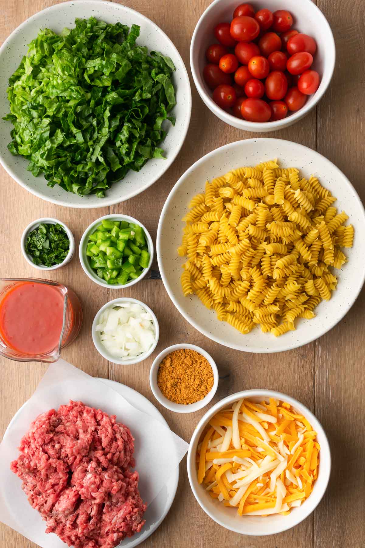 Ingredients for Taco Pasta Salad shown in white bowls.