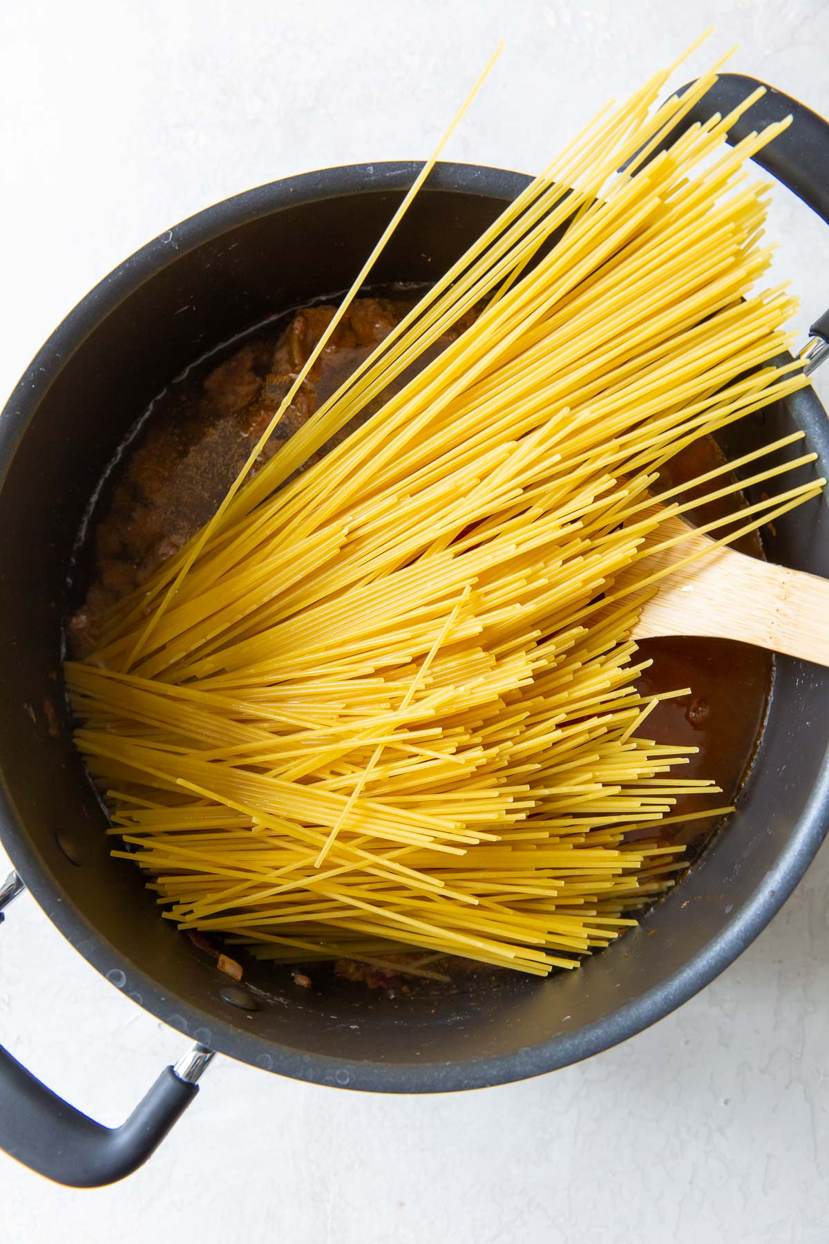 Adding pasta to one pot taco spaghetti.