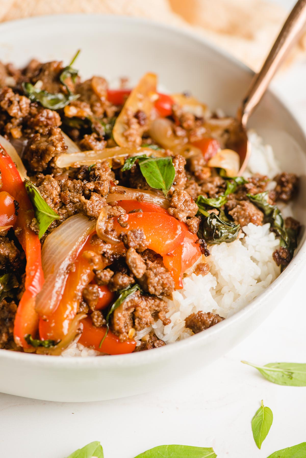 Closeup of a bowl of rice topped with Thai basil beef.